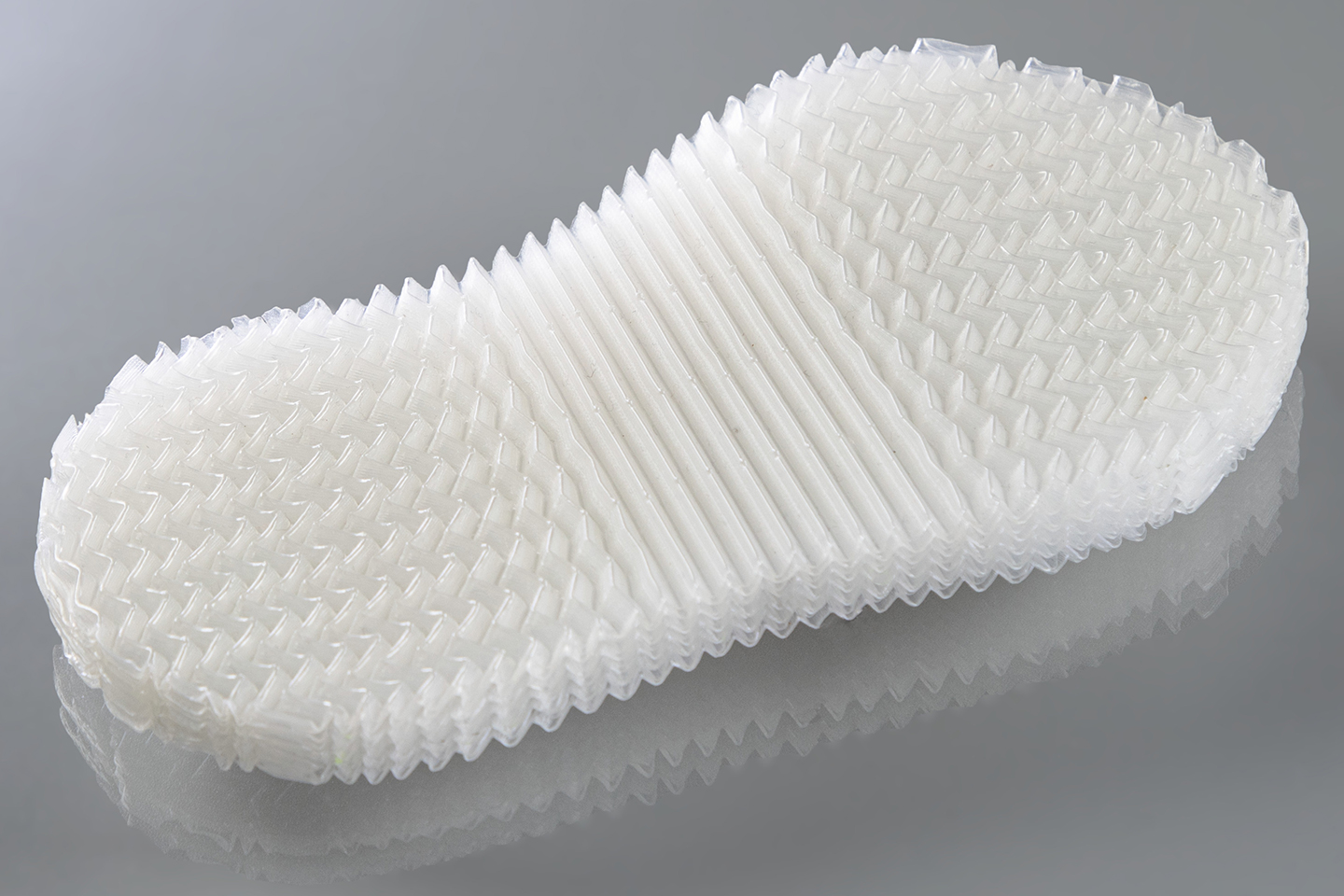 Programmierbare Kunststoffsohle mit funktionsintegrierter Strukturverformung: Dank einer gezielt gestalteten inneren Architektur verändert die Sohle ihr mechanisches Verhalten unter Druck. Solche programmierbaren Materialien reagieren auf Belastung mit vorhersagbaren Formänderungen – und übernehmen damit Aufgaben, die sonst zusätzliche mechanische Bauteile erfordern würden.